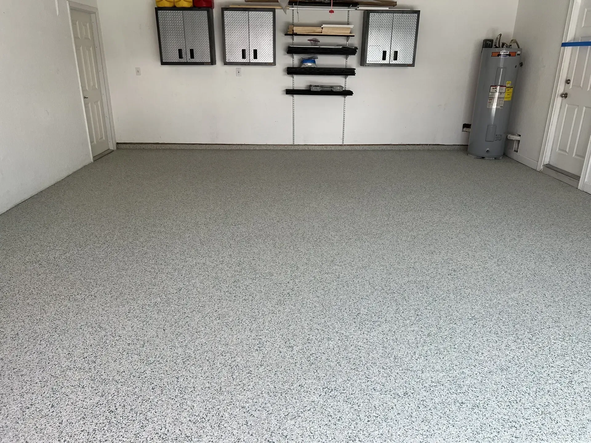 A clean, perfectly maintained gray decorative flake coating on an empty Fort Myers garage floor.