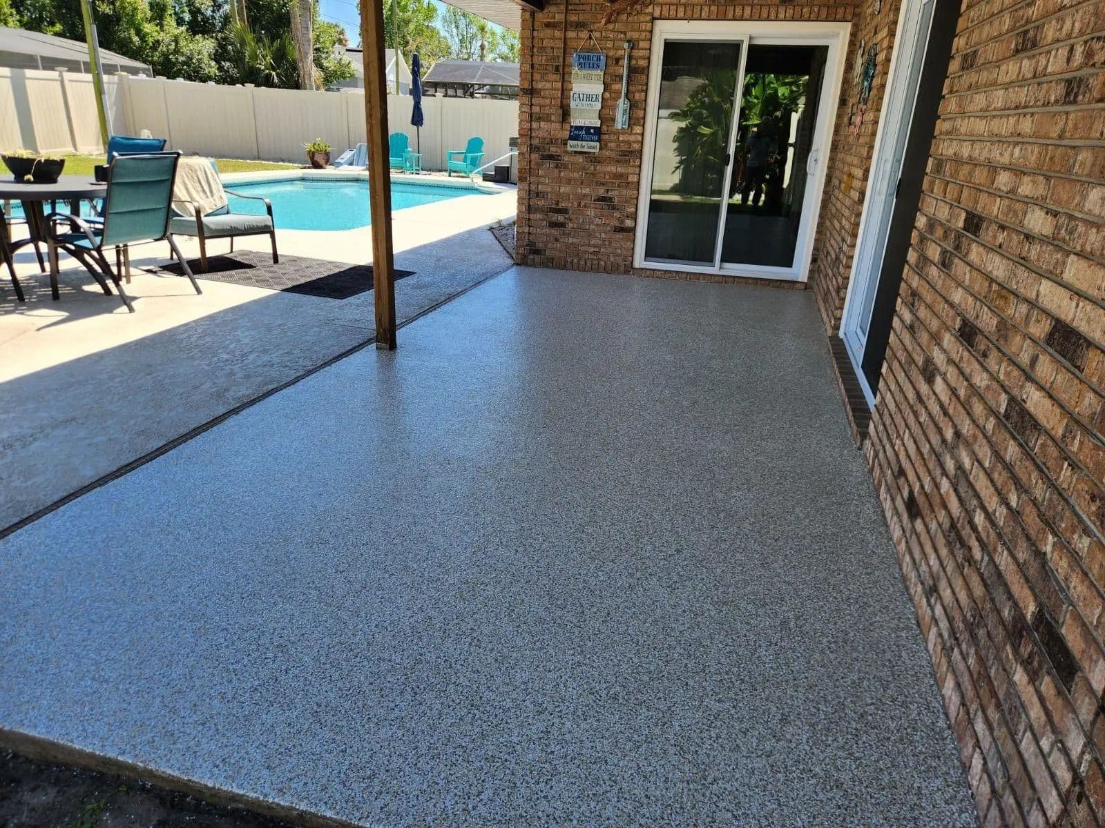 A covered outdoor brick patio featuring a slip-resistant, UV-stable polyaspartic concrete coating.