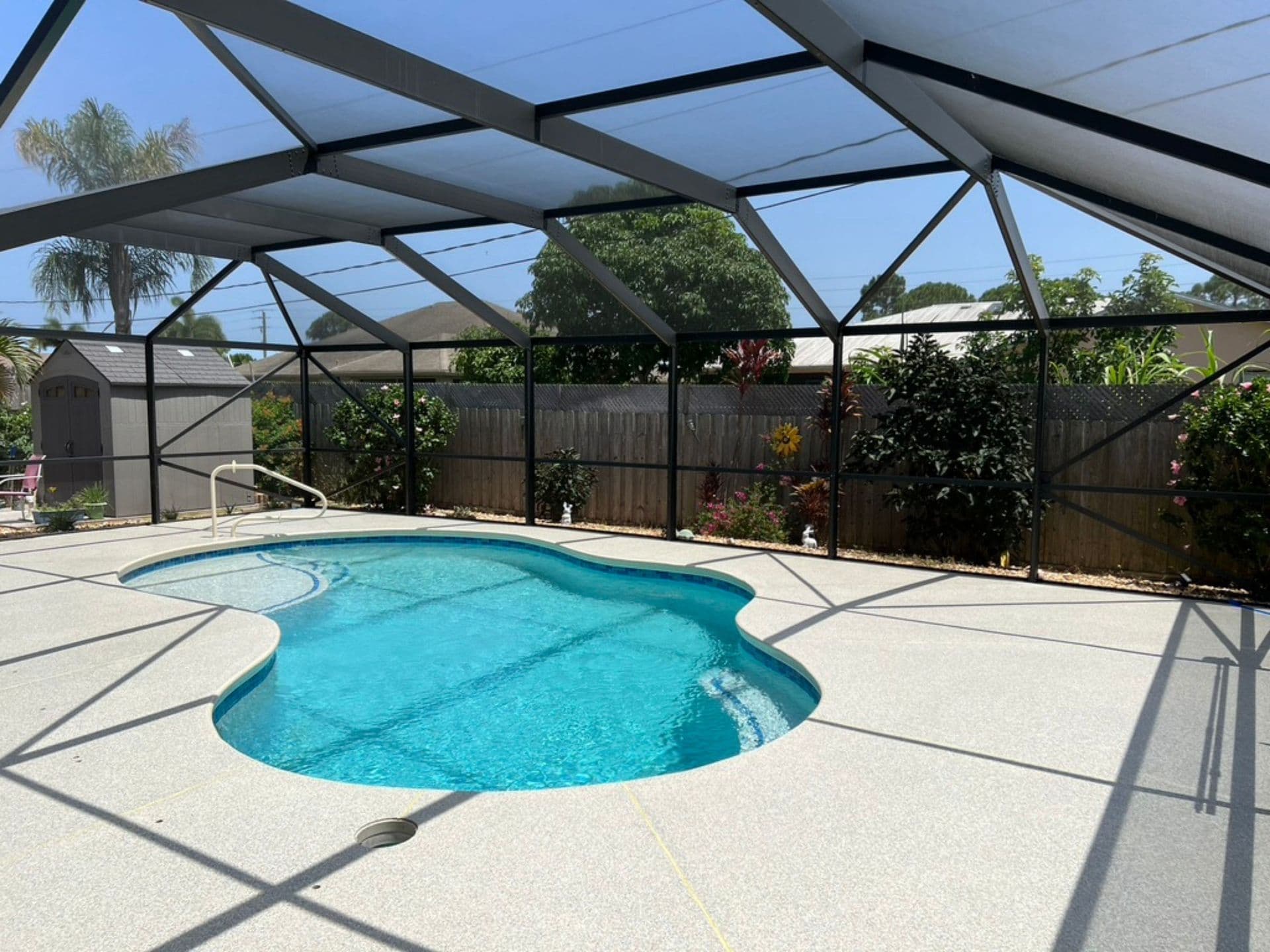 A light gray decorative flake non-slip coating applied to a residential pool deck