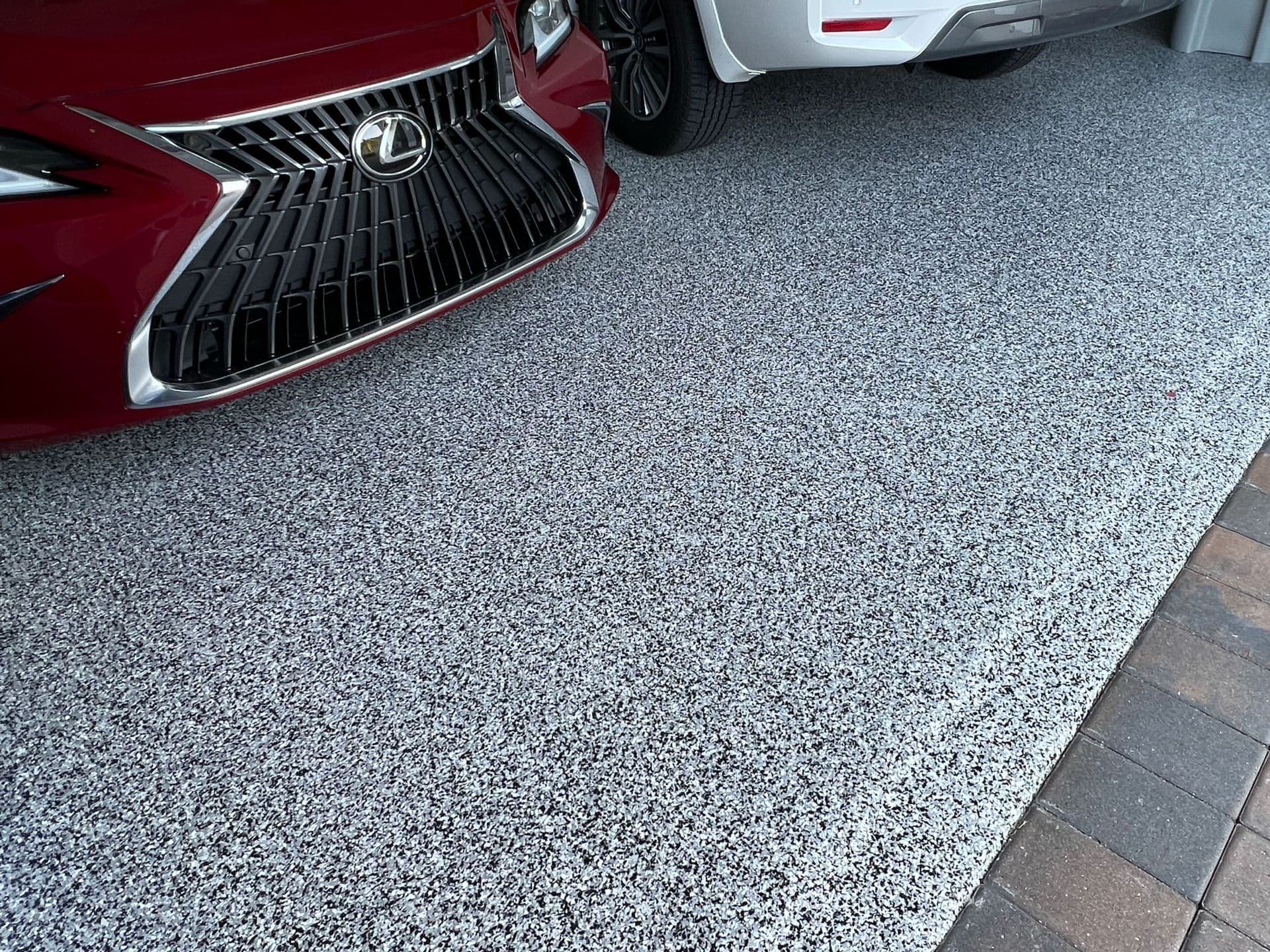 Gray decorative flake polyaspartic coating applied to a residential garage floor in Deerfield Beach
