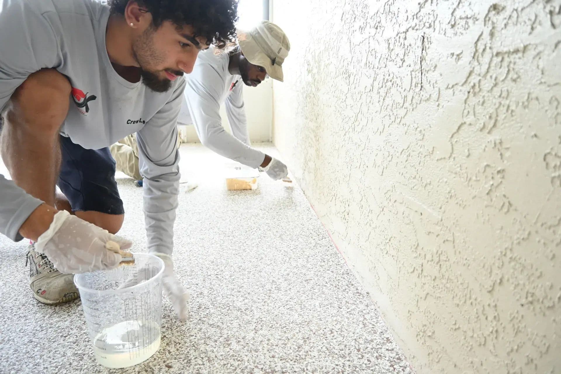 Professional flooring installers applying a durable polyaspartic coating